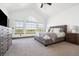 Bright and airy main bedroom with large windows, plush carpeting, and neutral decor at 2400 Ventress Ct, Bennett, CO 80102