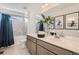 Bright bathroom with double sinks, vanity, tub/shower combo, neutral tile, and decorative wall art at 13838 Honey Hush Trl, Parker, CO 80134