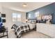 The bedroom features a blue accent wall, neutral carpet, natural light, and sports themed art at 13838 Honey Hush Trl, Parker, CO 80134