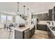Spacious kitchen featuring a center island with seating, modern appliances, and an open view of the dining area at 13838 Honey Hush Trl, Parker, CO 80134