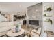 Open-concept living room with a modern fireplace and a view into the kitchen and dining area at 13838 Honey Hush Trl, Parker, CO 80134