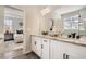 Dual-sink vanity with granite counters, white cabinetry and matte black hardware adjacent to the primary bedroom at 13838 Honey Hush Trl, Parker, CO 80134