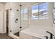 Modern main bathroom featuring a glass enclosed shower, a soaking tub, and matte black hardware at 13838 Honey Hush Trl, Parker, CO 80134