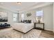 Bright main bedroom with an accent rug, tray ceiling, bedside lamps and tables, and decorative wall art at 13838 Honey Hush Trl, Parker, CO 80134