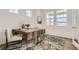 Well-lit office with a rustic wooden desk, comfortable chairs, and plenty of natural light from the windows at 13838 Honey Hush Trl, Parker, CO 80134