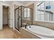 Spa-like bathroom with soaking tub, glass shower, and neutral tile, offering a relaxing retreat at 39172 Clymer St, Elizabeth, CO 80107