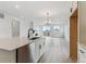 Bright, open kitchen features white cabinets, stone counters, stainless steel appliances, and flows into the adjacent living room at 39172 Clymer St, Elizabeth, CO 80107