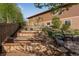 Landscaped backyard featuring multiple raised garden beds, stone steps, large boulders, and mature trees at 4000 Donnington Cir, Castle Rock, CO 80104