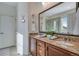Bathroom featuring double vanity with granite countertop, large mirror, and walk-in shower reflected in the mirror at 4000 Donnington Cir, Castle Rock, CO 80104