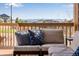 Cozy deck area with comfortable cushions and pillows and railing views of other homes and trees at 4000 Donnington Cir, Castle Rock, CO 80104
