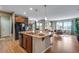 Open-concept kitchen features island, hardwood floors, and natural light from large windows at 4000 Donnington Cir, Castle Rock, CO 80104