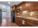 Well-equipped kitchen with dark wooden cabinetry and granite countertops, adjacent to living area at 4000 Donnington Cir, Castle Rock, CO 80104