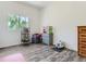 The bedroom features neutral paint, gray flooring, and a window to let in natural light at 10197 E Mississippi Ave, Denver, CO 80247