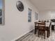 Bright dining area featuring wood-look floors, large windows, and a stylish, oversized clock at 10197 E Mississippi Ave, Denver, CO 80247