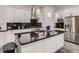 Modern kitchen featuring white cabinets, granite counters, stainless steel appliances, and pendant lighting at 10197 E Mississippi Ave, Denver, CO 80247