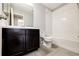 Stylish bathroom with a dark vanity, white tile, and a combined tub and shower at 16075 E Elk Pl, Denver, CO 80239