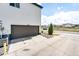 Attached garage featuring a brown garage door and a well-kept driveway with landscaping at 16075 E Elk Pl, Denver, CO 80239