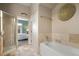 A luxurious bathroom with a soaking tub, glass shower and neutral tile throughout at 4001 W 32Nd Ave # 1, Denver, CO 80212