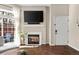 Cozy living room with a fireplace, tv, wood floors, and a glass sliding door to a private patio at 4001 W 32Nd Ave # 1, Denver, CO 80212