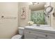 Well-lit bathroom features a large mirror, vanity with sink, and a shower with leafy curtain at 21422 E 47Th Ave, Denver, CO 80249