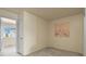 Airy bedroom with carpet, neutral walls, an open doorway and a vibrant painting on the wall at 21422 E 47Th Ave, Denver, CO 80249