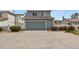 Exterior of two-car garage with large driveway and mature landscaping on a sunny day at 21422 E 47Th Ave, Denver, CO 80249