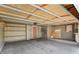 Spacious unfinished two-car garage featuring a service door, shelving, and storage potential at 21422 E 47Th Ave, Denver, CO 80249