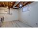Unfinished basement with window, vinyl floors, exposed ceiling, and laundry hook ups at 6844 S Broadway, Littleton, CO 80122