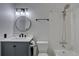 Updated bathroom featuring modern fixtures, including a round mirror, vanity, and shower at 6844 S Broadway, Littleton, CO 80122