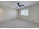 Spacious bedroom featuring plush carpet, ceiling fan, and natural light from a shuttered window at 6844 S Broadway, Littleton, CO 80122