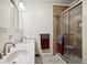 This bathroom features double sinks, a tiled shower with glass door, and neutral color palette at 11094 Thomas Dr, Conifer, CO 80433