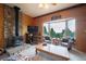Cozy living area with a stone fireplace and a large window offering scenic views at 11094 Thomas Dr, Conifer, CO 80433