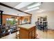Mountain-view living room with wood walls, skylights, and seamless access to kitchen at 11094 Thomas Dr, Conifer, CO 80433