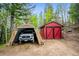 Outdoor storage with a detached red shed and vehicle carport, nestled among the trees at 11094 Thomas Dr, Conifer, CO 80433