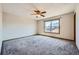 Spacious bedroom with plush gray carpeting, a ceiling fan, and a large window providing natural light at 3334 Navajo St, Denver, CO 80211