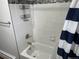 Clean bathroom with white tiled walls and updated fixtures at 1530 Whippoorwill Dr, Lakewood, CO 80215