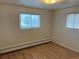 Bedroom featuring hardwood floors and abundant natural light from two windows at 1530 Whippoorwill Dr, Lakewood, CO 80215