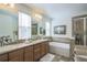 Spacious bathroom featuring dual sinks, soaking tub, a separate glass door shower, and decorative tile work at 3754 Broadview Pl, Castle Rock, CO 80109