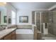 Elegant bathroom featuring a soaking tub, a glass door shower, decorative tiles, and soft, neutral tones at 3754 Broadview Pl, Castle Rock, CO 80109