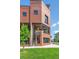 Stunning exterior of a modern brick townhouse with a well-manicured front lawn and greenery at 485 E Arizona Ave, Denver, CO 80210