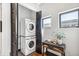 Bright laundry room with stacked washer and dryer and a dark wood accent table at 485 E Arizona Ave, Denver, CO 80210