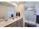Modern bathroom with double vanity, tile flooring, and a glass-enclosed shower at 7022 Todd Ct, Frederick, CO 80530