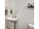 This powder room is equipped with a pedestal sink, oval mirror, and space-saving toilet paper rack at 7022 Todd Ct, Frederick, CO 80530