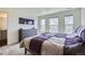Cozy bedroom with a purple patchwork quilt, a dresser and large windows for natural light at 7022 Todd Ct, Frederick, CO 80530