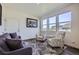 Bright living room features large windows, a gray sofa, and two armchairs with floral accents at 7022 Todd Ct, Frederick, CO 80530