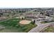 An aerial view shows a community park with athletic fields, a playground and neighborhood school close to residential area at 464 Chiswick Cir, Highlands Ranch, CO 80126