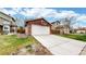 Red brick detached garage with a white door and basketball hoop, showcasing a spacious driveway and landscaping at 464 Chiswick Cir, Highlands Ranch, CO 80126