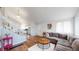 Open-concept living area with hardwood floors, a plush couch, and staircase access at 464 Chiswick Cir, Highlands Ranch, CO 80126