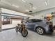 View of open garage with car, motorcycle, and overhead storage at 4125 Coriander St, Castle Rock, CO 80109