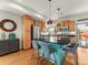 Bright kitchen with stainless steel appliances, wood cabinets, a blue island with bar seating and granite countertops at 4125 Coriander St, Castle Rock, CO 80109